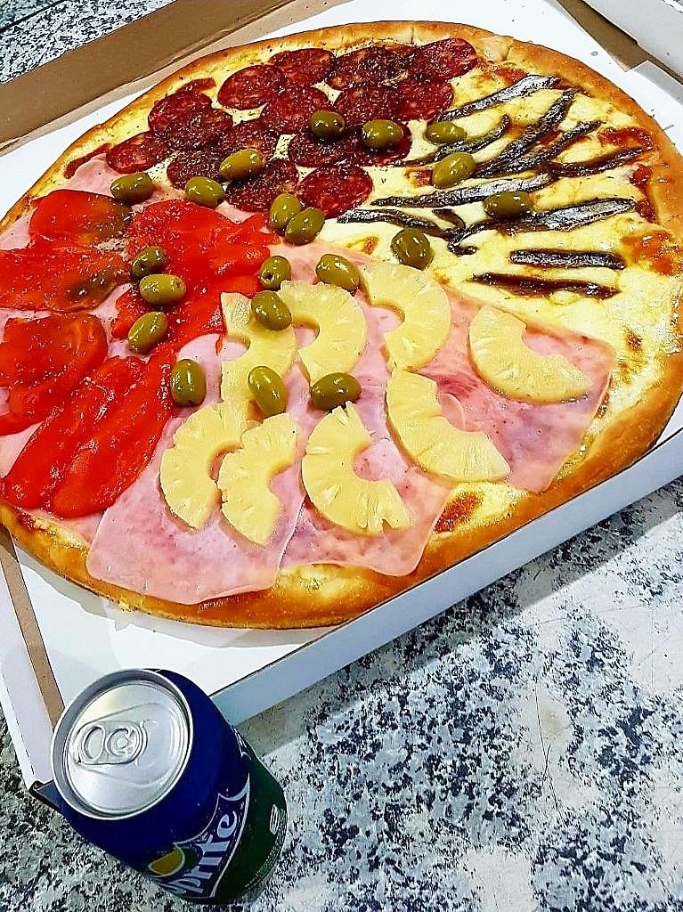 Pizza con salame, morrón, jamón y ananá, y anchoas